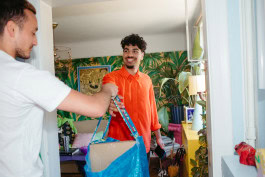 Courier gives parcel to man in doorway 