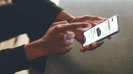 A man holds a phone with an open FINN application in his hands 