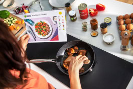 Woman preparing dinner at the stove following a HelloFresh recipe 