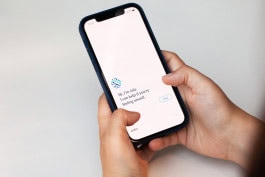 A person holds a phone in their hand where the Ada app is open 