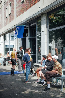 People chatting at a fashion event near a clothing store