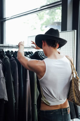 Man choosing clothes on hangers in a store