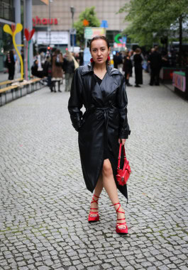 Woman posing with black leather coat and red shoes