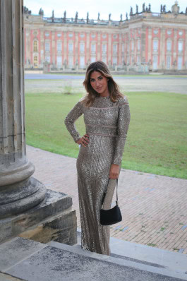 Woman posing in silver shiny tight long dress