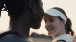 Still from the movie Sasporumpet Still where two women smile at each other in sportswear
