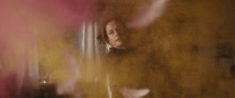 Still from the film Highly Explosive where a woman is depicted in a blurred, hazy frame