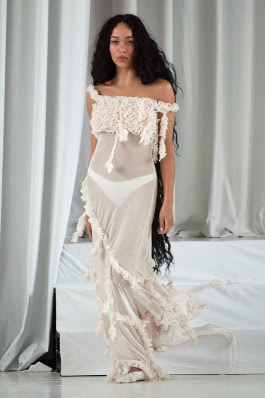 A female model of the Clara Colette Miramon brand in a white translucent dress walks the catwalk at Berlin Fashion Week