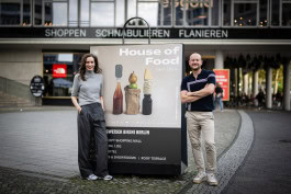 Michael Hetzinger and Alexandra Laubrinus atsnding near House of Food poster
