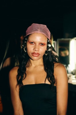 A model from the Namilia brand applying makeup on the backstage of Berlin Fashion Week
