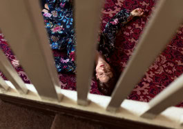 photo of a woman lying on a carpet, view from the stairs