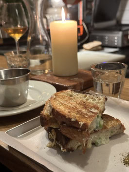 Sandwich drinks and a candle at a table in The Rad bar in Berlin
