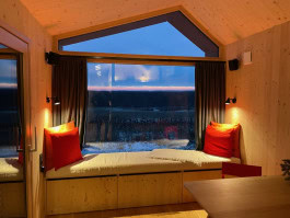 Window with soft window sill and cushions in the evening and view of the winter landscape at Auszeit Tollensesee