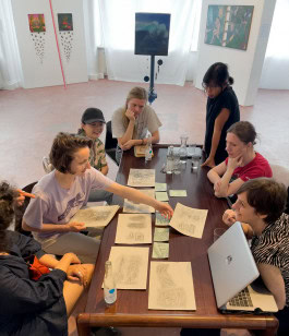 people at the table sharing ideas art concepts at SomoS Arts