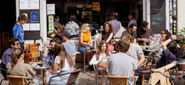 People drink wine and eat on the summer terrace at The Rad bar in Berlin 
