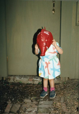 photo of little girl putting elephant mask on her head