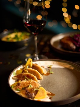 Table at Crackers Berlin on Christmas 2024 with a glass of red wine and gyoza