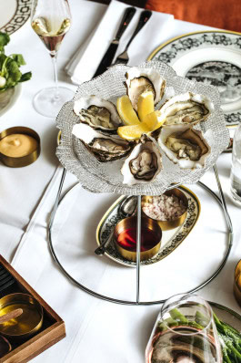 Table with dishes at Papillon, oysters in the foreground