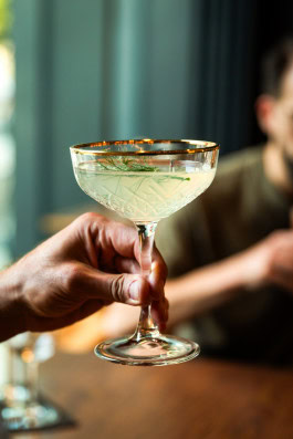 Hand holding a cocktail at Dry Gin & Beef Club