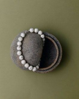 Bracelet of white stones with black speckles in a stone box 