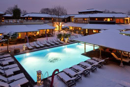 Swimming pool in winter, sun loungers around and the Vabali Spa building