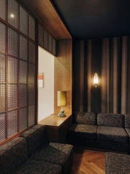 Château Royal interior, sofas stand in the corner in a room with subdued lighting 