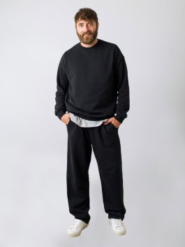 man posing in black sweatshirt and black sweatpants