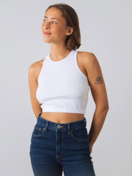 woman in white crop top posing with hands in back jeans pockets 