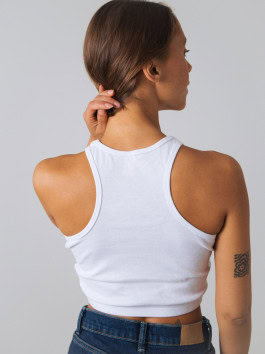 woman posing with her back in jeans and a white top