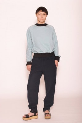 woman posing in pale blue sweatshirt, black sweatpants and platform sandals