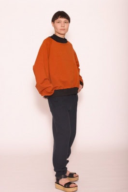 woman posing in red sweatshirt, black sweatpants and platform sandals 