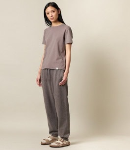 woman posing in grey t-shirt, grey sweatpants and beige sandals