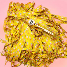 a tube from which came out a multitude of yellow shoe laces with an ice cream cone print